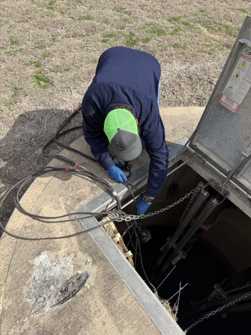 Worker inspecting equipment inside an underground vault.