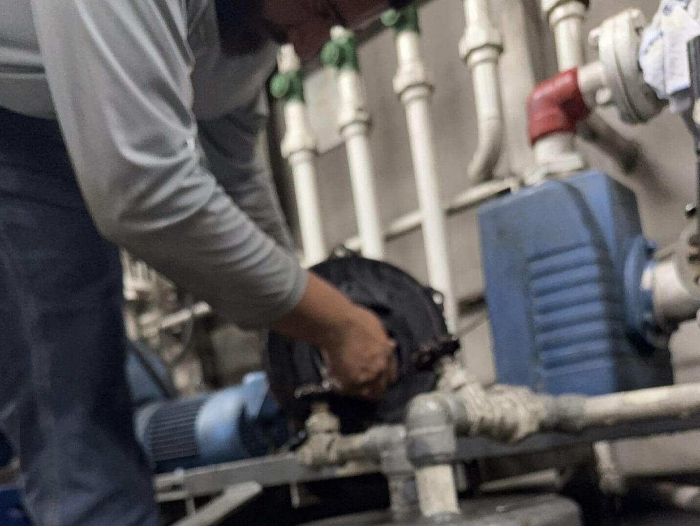 Person repairing industrial machinery with tools.